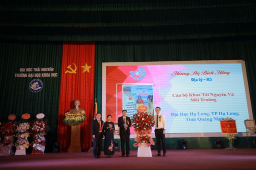 Đại diện cựu SV tặng hoa chúc mừng Nhà trường